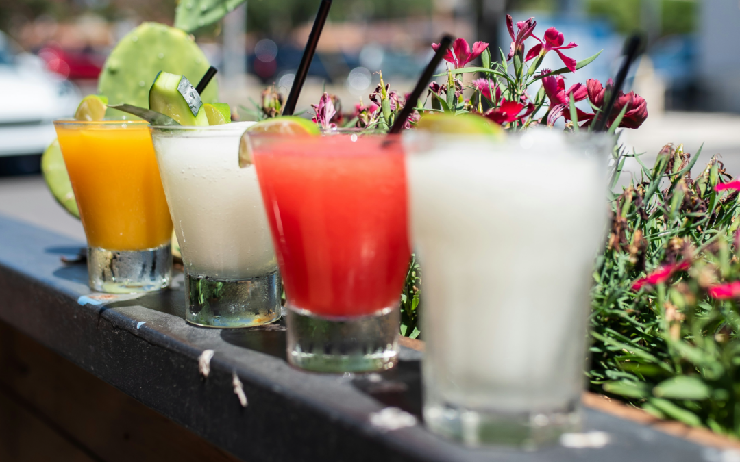 4 cocktails on a ledge outside